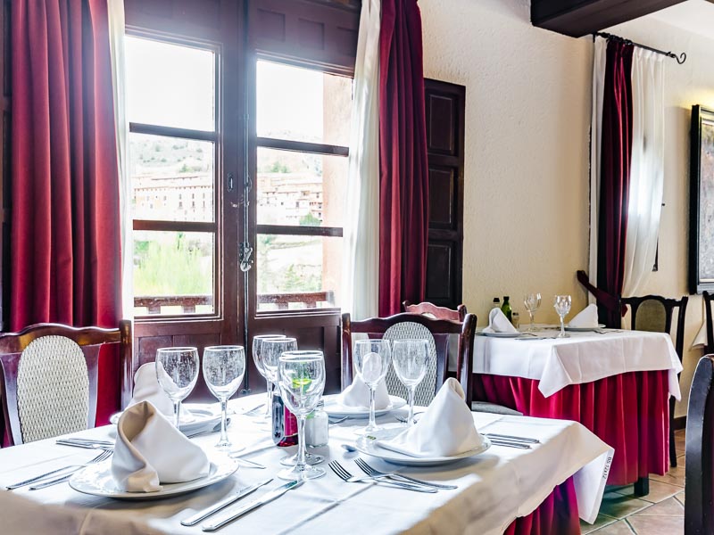 Comedor del Hotel Albarracín preparado junto a los ventanales