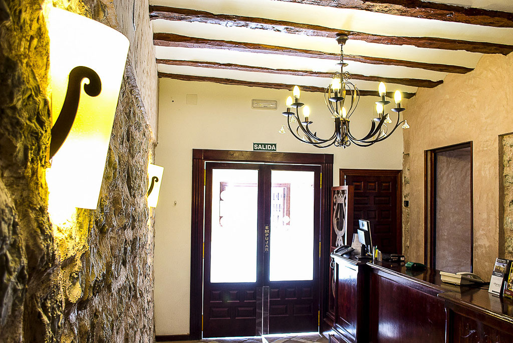 Recepción del Hotel Arabia con vigas de madera y mostrador oscuro