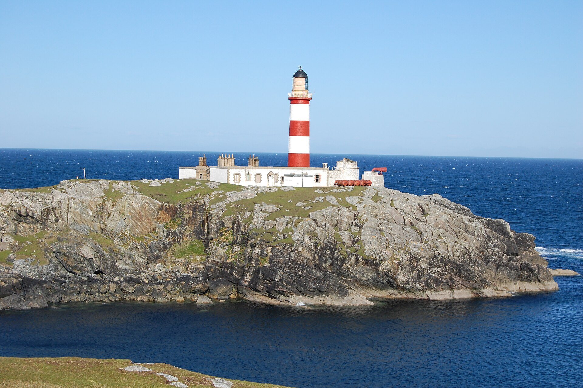 Faro de Eilean Glas visto entre roca y hierba en la isla de Scalpay