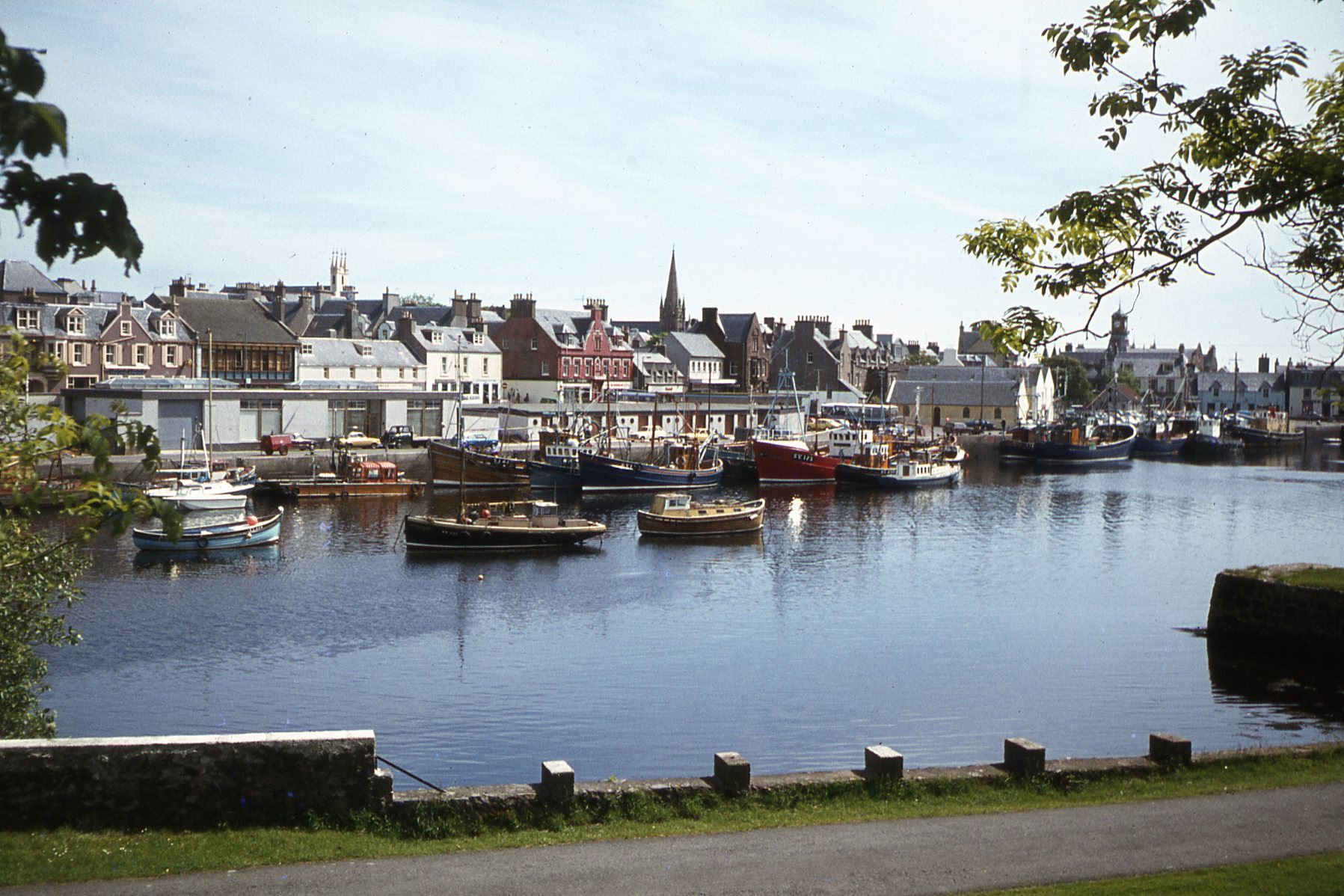 Puerto de Stornoway con embarcaciones y edificios reflejados en el agua