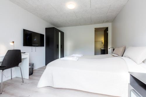 Dormitorio blanco con cama grande en Gjaargardur Guesthouse Gjogv