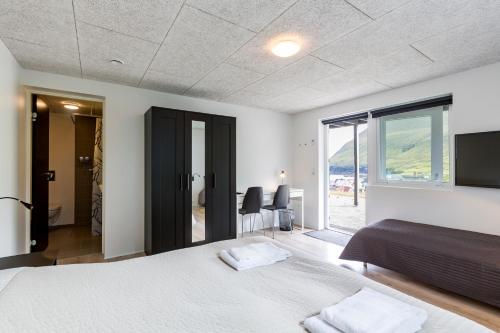 Habitación con cama y vistas al océano en Gjaargardur Guesthouse Gjogv