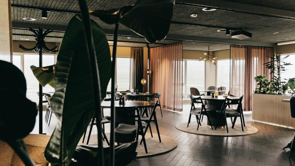 Restaurante con mesas y plantas en Hotel Vagar en Sørvágur