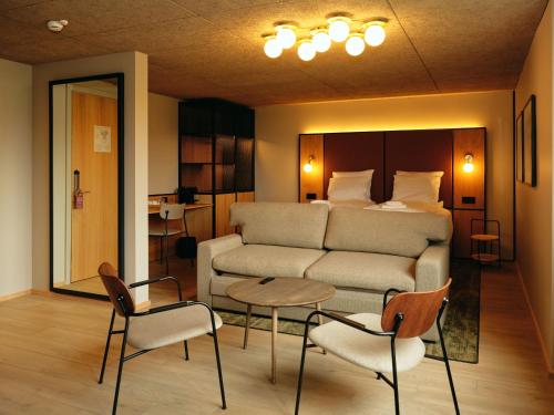 Sala de estar con cama y sofá en Hotel Vagar
