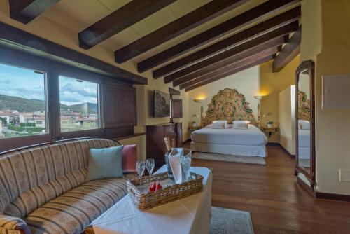 Sala de estar con sofá y cama en Hotel Cal Sastre, en Santa Pau
