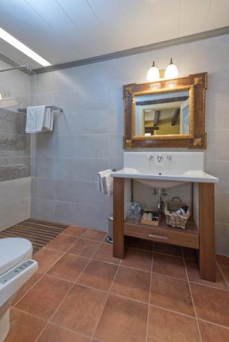 Baño con lavabo y espejo en Hotel Cal Sastre, en Santa Pau