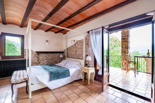 Habitación con cama y balcón en Hotel Mas la Ferreria, en La Vall de Bianya