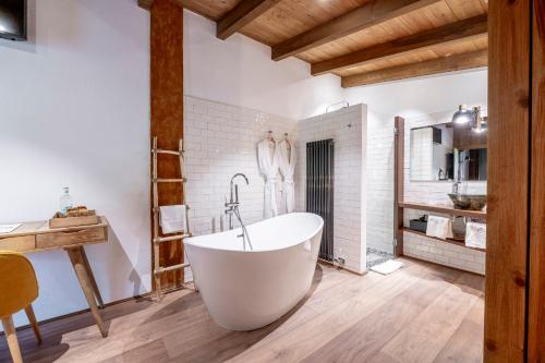 Baño con bañera blanca en una habitación de Hotel Mas la Ferreria, en La Vall de Bianya
