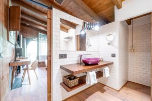 Baño con lavabo y un cuenco rosa sobre la encimera en Hotel Mas la Ferreria, en La Vall de Bianya