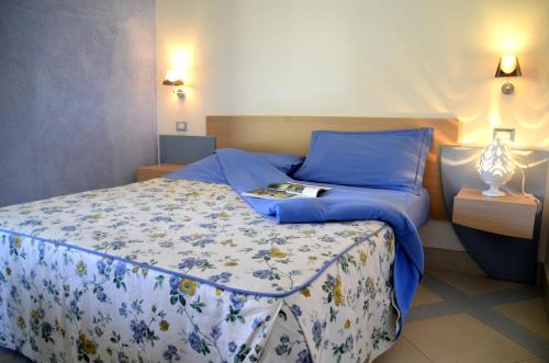 Dormitorio con cama doble y almohadas azules en Masseria Asciano