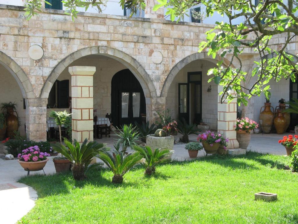 Patio ajardinado con arcos de piedra en Masseria Asciano