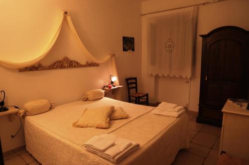 Dormitorio con cama doble y textiles claros en LAMA DI GALIZIA